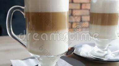 <strong>咖啡</strong>拿铁，牛奶和空气泡沫，黑色吸管站在透明的特殊玻璃桌上时髦的<strong>咖啡</strong>馆